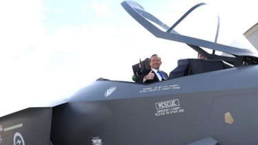 Prime Minister Tony Abbott in the cockpit of of a replica Joint Strike Fighter.