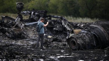A journalist takes photographs at the site of the Malaysia Airlines Boeing 777 plane crash in Ukraine.