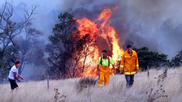 Robert and Bev Thornton are helped by their son, Matthew, as they watch a bush fire near their property in Dereel.