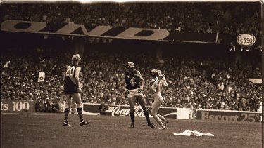 Streaker Helen D'Amico runs up to Carlton player Bruce Doull during the 1982 AFL grand final.