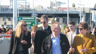 Lord Mayor Campbell Newman walks over the new bridge with members of the Go-Betweens.