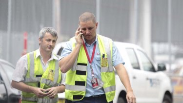 Qantas workers leave the international terminal at Sydney Airport several hours after the company announced it would retrench thousands of staff.