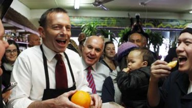 Opposition Leader Tony Abbott packs easy-peel oranges during a visit to Fruit World fruit and vegetables shop in the marginal seat of Deakin with Liberal candidate Phil Barresi in the Melbourne suburb of East Ringwood today.