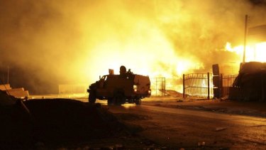 Fighting continues: A building burns after clashes between rival militias in the Sarraj district of the Libyan capital Tripoli.