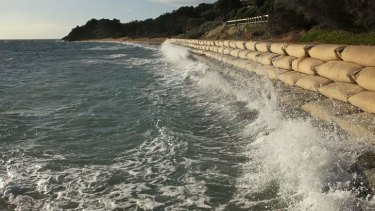 Rising tide: waves crash into sandbags where Victoria's Portsea Beach used to be.