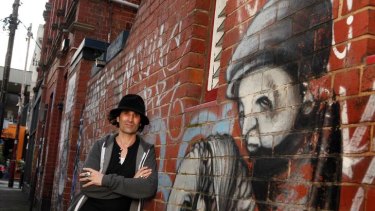 Stormie Mills with some of his Melbourne street art in Prahran.