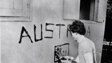 Just days before his death, Greg Shackleton paints "Australia" on a shop wall in Balibo in East Timor in 1975.