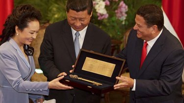 China's President Xi Jinping, centre, and his wife Peng Liyuan hold the key to the city given to them by San Jose Mayor Johnny Araya in California.