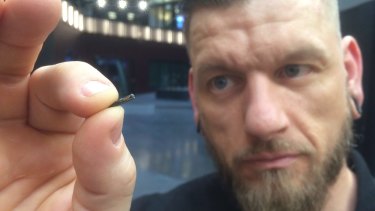 Jowan Osterlund from Biohax Sweden holds a small microchip implant, similar to those implanted in workers at the Epicenter hub in Stockholm.