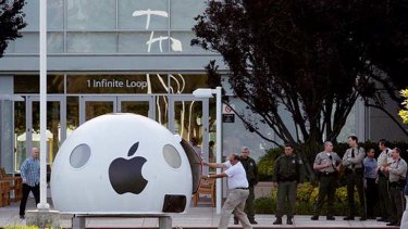 A security official forces open the door of a pod delivered by Greenpeace activists at Apple's Cupertino headquarters.