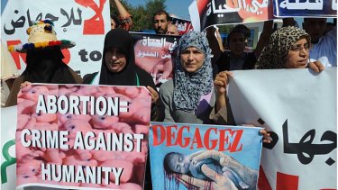 Moroccan protesters hold slogans to protest against abortion at the entrance of the Mediterranean Marina Smir harbour.