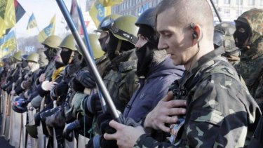 Anti-government protesters armed with sticks and shields sing the national anthem during a in central Kiev, Ukraine. 