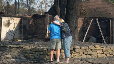 A couple look at a house burnt out by bushfires in Winmalee in Sydney's Blue Mountains.