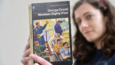 Laura Wood of Skoob Books poses for a photograph with a copy of George Orwell's '1984' in central London.