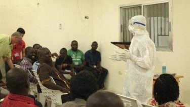 Medical personnel demonstrate protective equipment to educate team members on the Ebola virus  in Liberia.