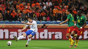 Robin Van Persie of the Netherlands scores the opening goal against Cameroon.