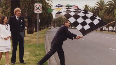 Pic published and filed: 12-6-94 Photo by John Lamb. Victorian premier, Jeff Kennett waves chequered racing flag at Albert Park while Ron Walker and Judith Griggs look on. The three had gathered to open new offices for Melbourne Major Events and Melbourne Grand Prix Promotions.