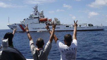 Philippine Marines gesture towards a Chinese Coast Guard vessel, trying to block a Philippine supply ship reaching disputed Spratly Islands, in the South China Sea March 29, 2014.