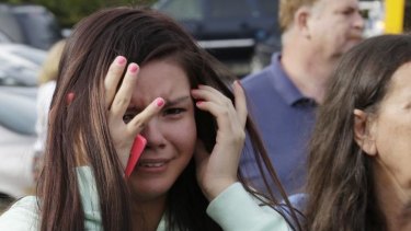 A young woman cries as she waits at a church where students were taken to be reunited with parents following a shooting at Marysville Pilchuck High School in Marysville, Washington.
