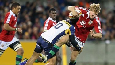 Crashing back to earth: Billy Twelvetrees of the Lions is tackled by Matt Toomua.