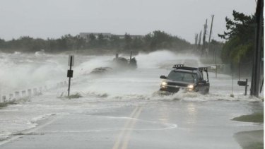 A truck drives through storm surge flooded road during Superstorm Sandy on October 29, 2012. The global warming report says we should expect more extreme weather.