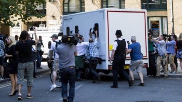 Taken away: Photographers try to get a shot inside a van believed to hold Rolf Harris after his sentencing. 