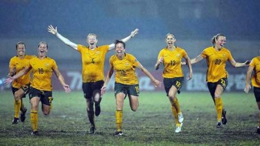 Australian players celebrate after winning the penalty shootout that secured Asian Cup victory in China on Sunday night.
