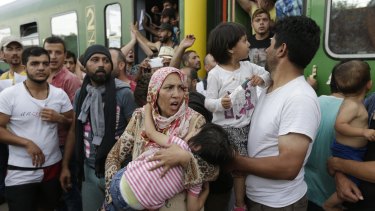 Migrants stand outside a train in Bicske, Hungary.
