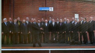 The Men in Suits choir, fronted by conductor Stephen Taberner, performs  an impromptu concert on the platform at Armadale railway station.