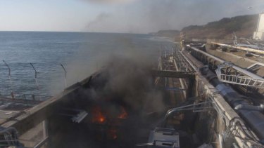Fire and smoke are seen at a building for sampling from seawater near No.4 reactor of the  Fukushima Daiichi nuclear plant.