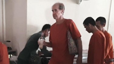 Australian filkmmaker James Ricketson is led into a court in a Phnom Penh.
