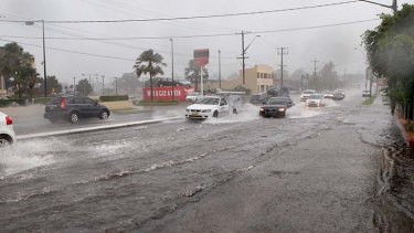 Flash flood: motorists drive through water on the Princes Highway at Carlton.