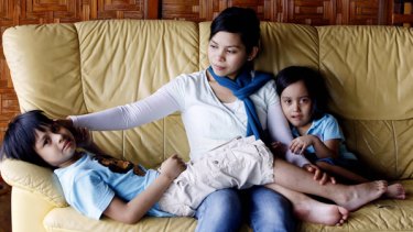 Muslim model Kartika Sari Dewi Shukarno, who was sentenced to be caned for drinking beer, sits with her children Muhammad, 7, left, and Kaitlynn, 5, at her father's home in Karai, north of Kuala Lumpur, Malaysia, Friday, Aug. 21, 2009.