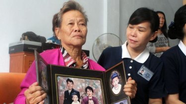 Grieving Indonesian mother Suharni displays a portrait of her son Sugianto Lo and wife Vinny Chynthya who are both passengers of the missing Malaysia Airlines flight MH370.
