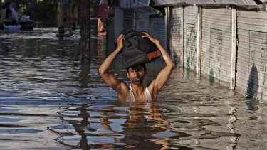 A Kashmiri man wades through a flooded street as he moves towards higher ground in Srinagar.