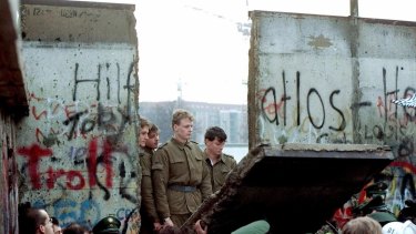 East German border guards on the Eastern side of the Berlin Wall as it comes down in November, 1989.