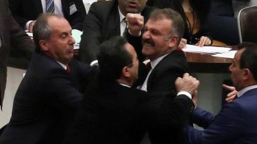 Deputy leader of the main opposition Republican People's Party Bulent Tezcan (centre-left) scuffles with ruling Justice and Development Party's parliamentarian Oktay Saral (centre).