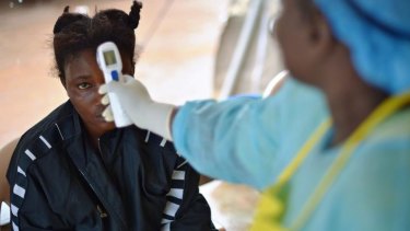 A girls suspected of being infected with the Ebola virus has her temperature checked at the government hospital in Kenema, Sierra Leone.