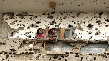 Still standing: Palestinian girls look out from the balcony of their home in Rafah that sat in the line of fire during the Israeli offensive in Gaza.