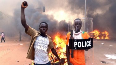 Protesters with a police shield outside parliament in Ouagadougou.