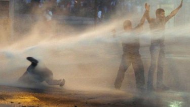Supporters of opposition leader Leopoldo Lopez are hit by a police water canon during a protest in Caracas, Venezuela.