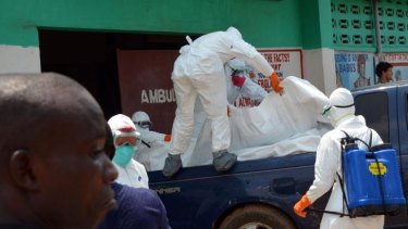 Liberian Red Cross health workers wearing protective suits carry the body of a 18-month-old victim of the Ebola virus in Monrovia.