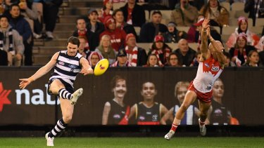 Swan dive: Sydney's Jarrad McVeigh, in his 300th game, tries to spoil Patrick Dangerfield of the Cats.