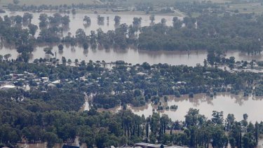 A levee holds flood waters from Wagga Wagga CBD in the foreground while North Wagga is inundated yesterday.