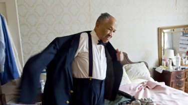 Eugene Allen, who served eight presidents including Ronald Reagan, tries on his old tuxedo.