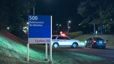 Police cars are seen in front of the prison near Quebec City after the jailbreak. 