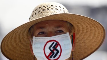 Pandemic 'imminent' ... a woman wears a surgical mask, painted to indicate her frustration with the current state of world affairs, in Mexico City.