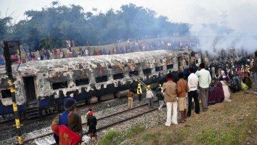 Shocked onlookers gather as rescue workers do what they can amid the smouldering ruin of the Howrah-Dehradun train.