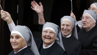 Nuns wave during a visit to a home for the elderly.