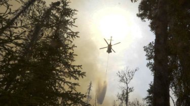 A helicopter dumps water on a portion of the Funny River fire.